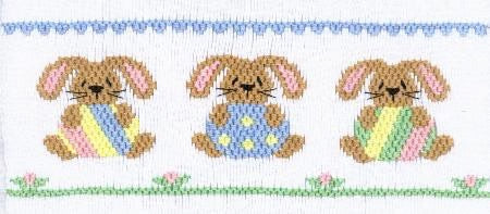 Smocking plate with three bunnies holding Easter eggs. 8 rows of smocking on a yoke.