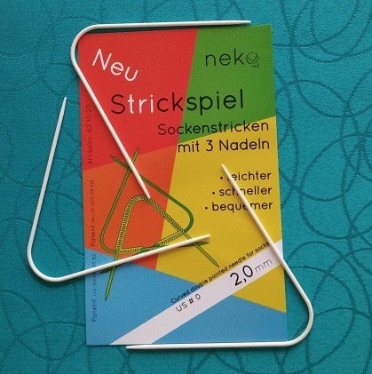 set of 3 curved double point knitting needles on a multi-colored background