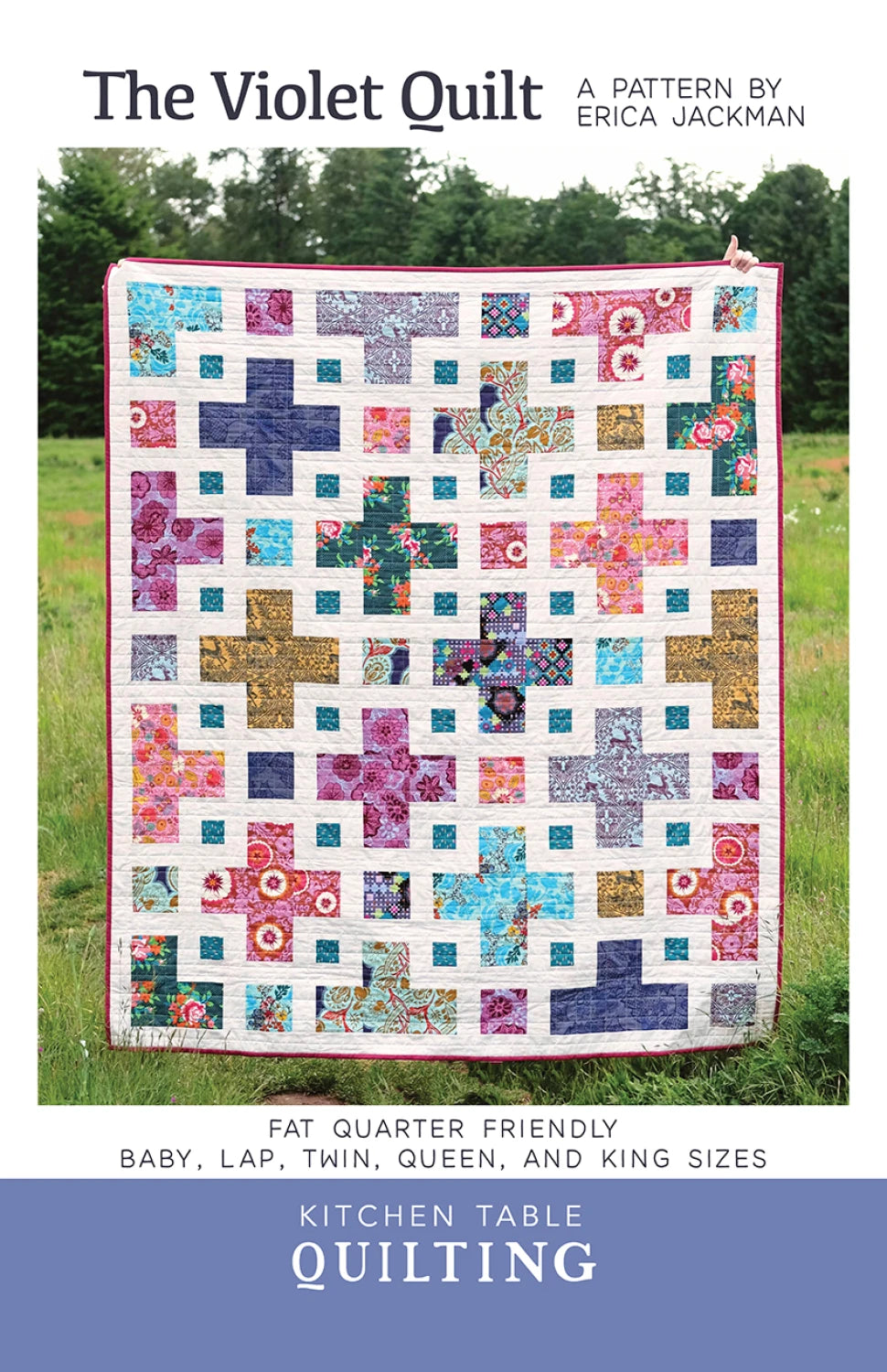 Colorful quilt with geometric pattern on a grassy background, featuring text about Kitchen Table Quilting.