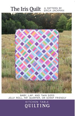 Pattern cover for 'The Iris Quilt' by Erica Jackman, showing a colorful patchwork quilt with pink, purple, blue, and yellow geometric designs. The quilt is pictured outdoors on a grassy field, with the title and text details for kitchen table quilting on a white and purple background.