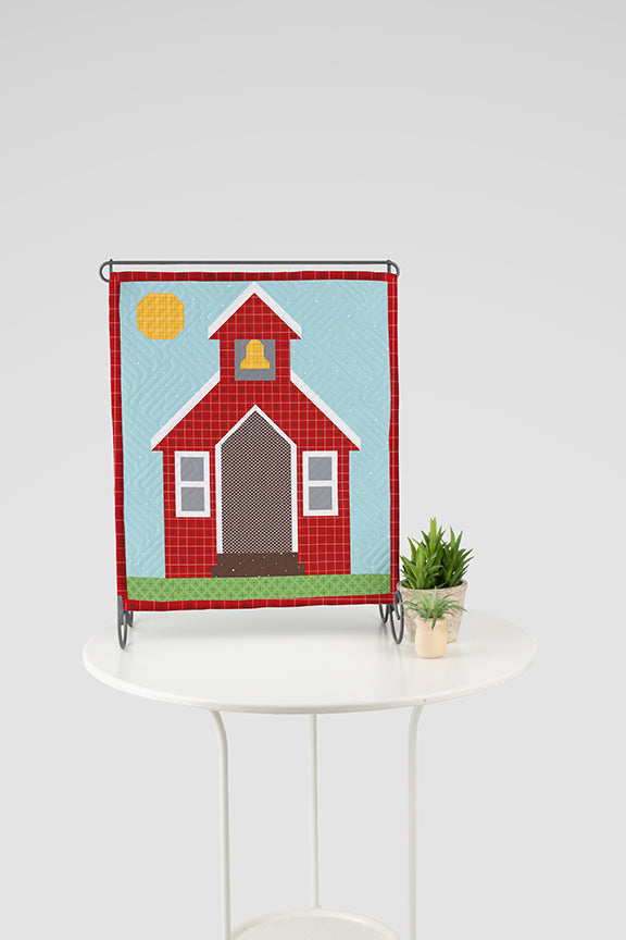 In Session Tabletop Banner Boxed Kit with a red school house. The Banner is hanging and sitting on a tabletop