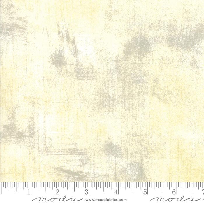 Textured fabric pattern with a ruler at the bottom for scale, featuring shades of beige and gray.