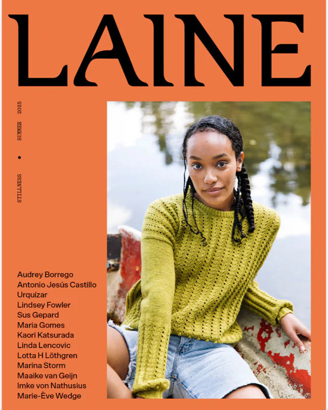 On an orange background with the magazine title "LAINE" in black across the top, a picture of a young black woman with shoulder length braids wearing a green knitted summer sweater, sitting in a canoe on a lake.