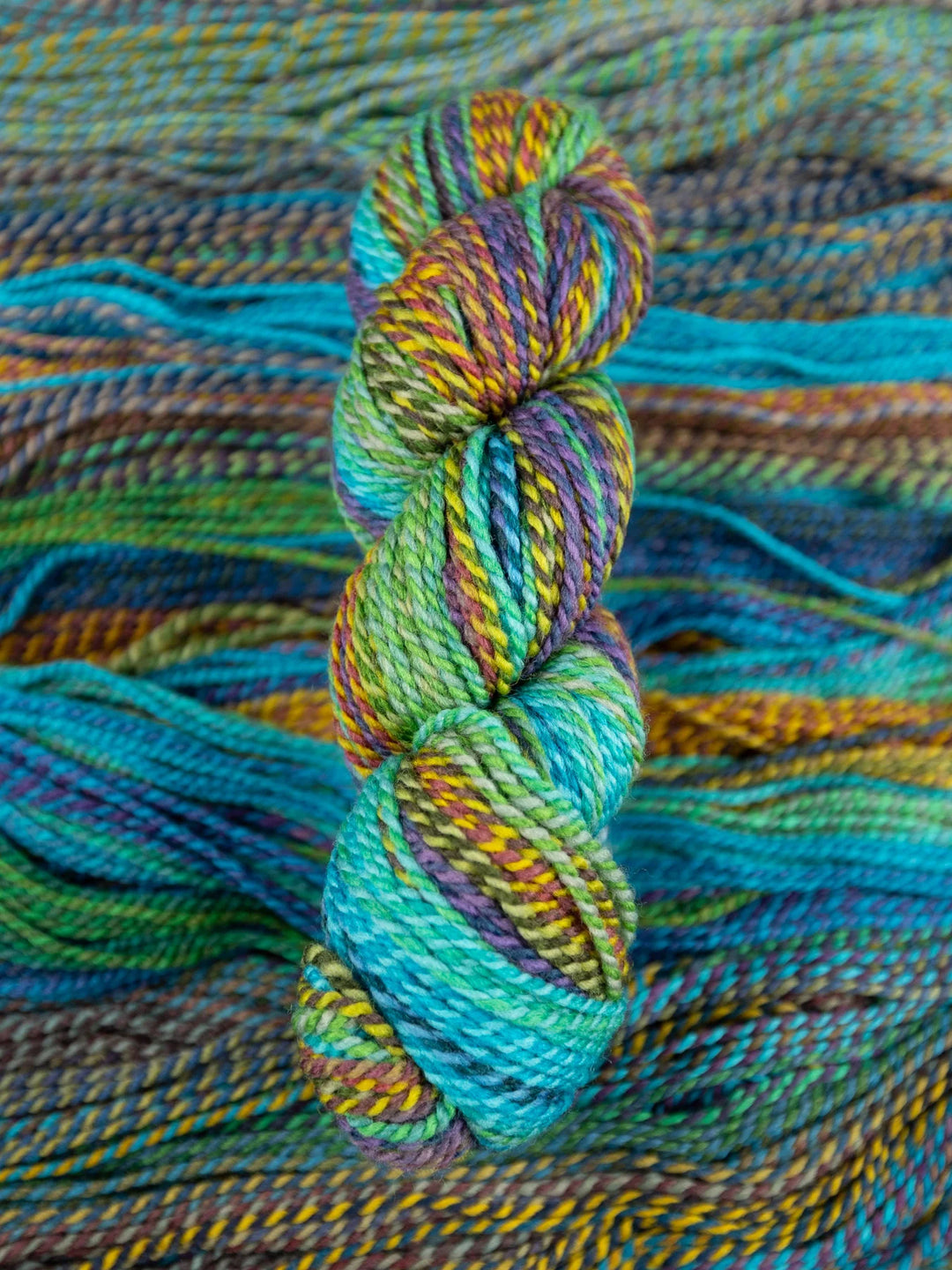Colorful skein of yarn on a textured fabric background