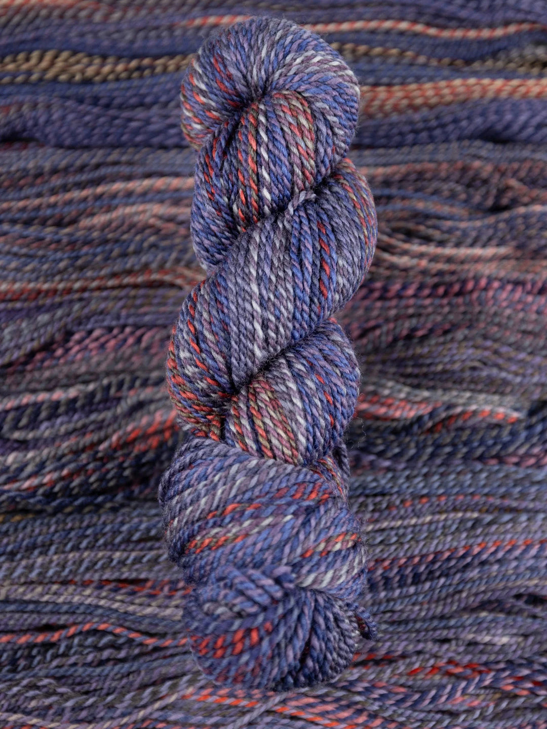Blue and red skein of yarn on a textured fabric background