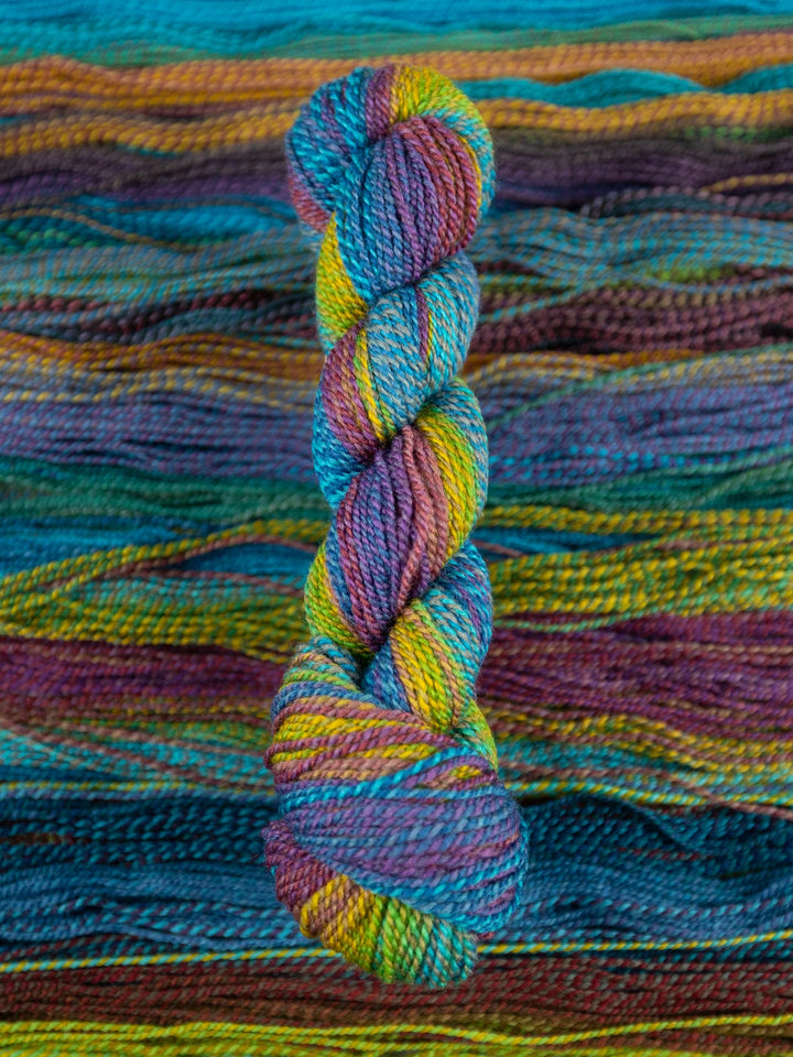 Colorful skein of yarn on a textured fabric background