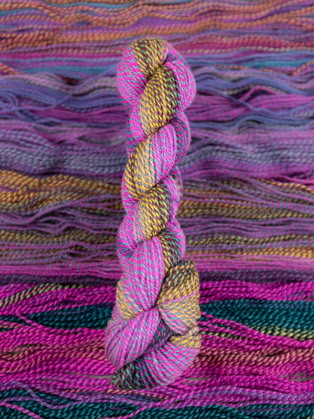 Colorful skein of yarn on a textured fabric background