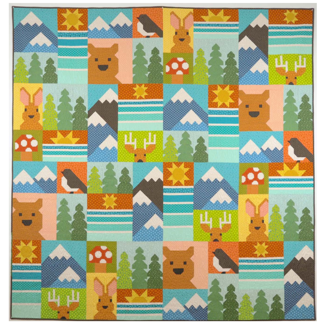 Children's quilt with a pattern of animals, trees, and mountains on a blue background