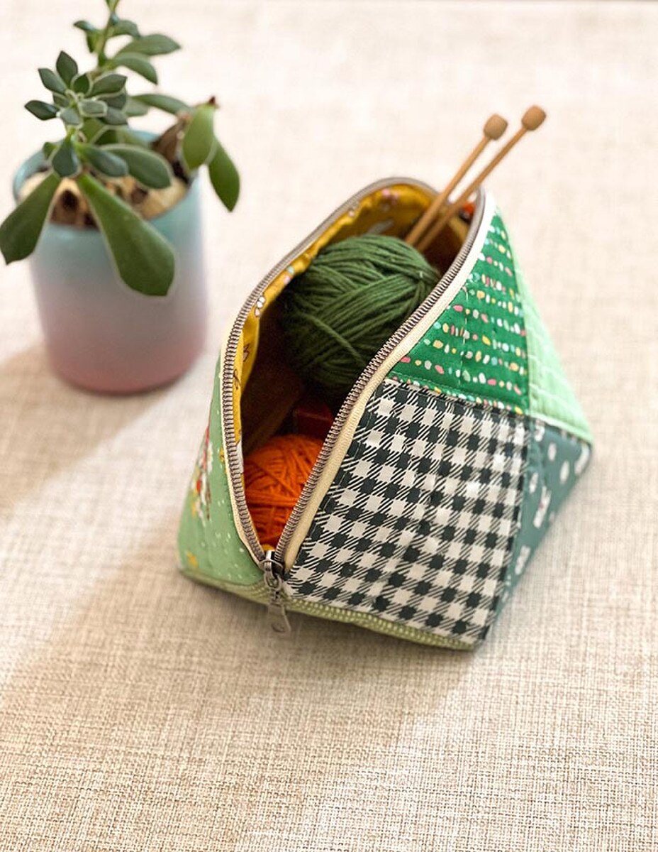 Fabric pouch with yarn and knitting needles on a textured surface