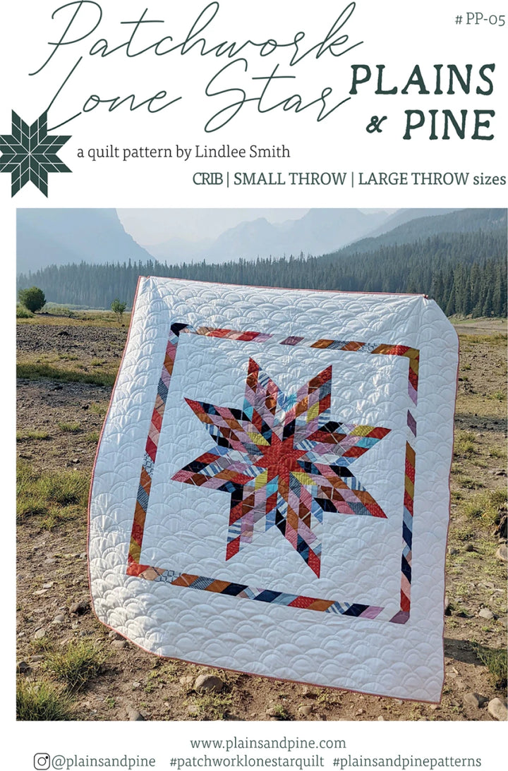 Quilt with star design in a field with mountains in the background