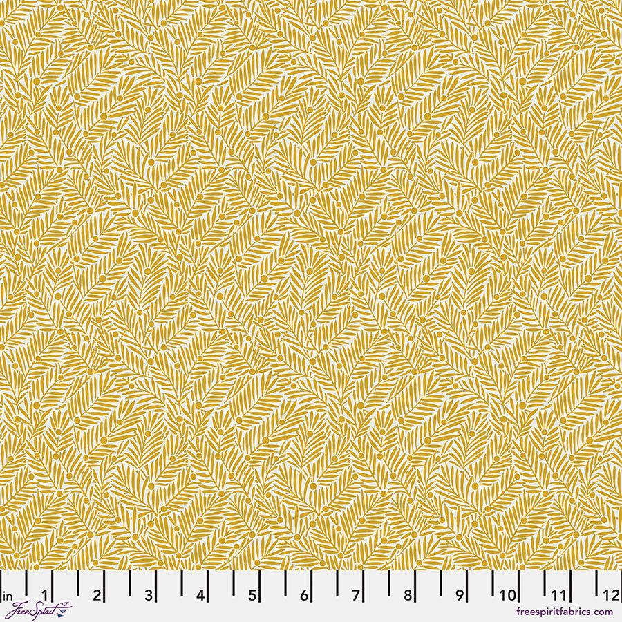 Fabric with a yellow leaf pattern and a ruler at the bottom for scale.