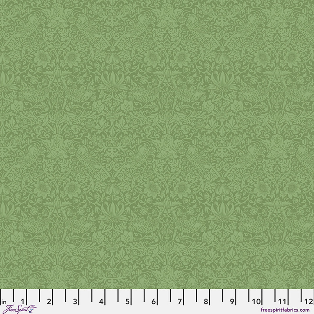 Green fabric with a subtle pattern and a ruler at the bottom for scale.