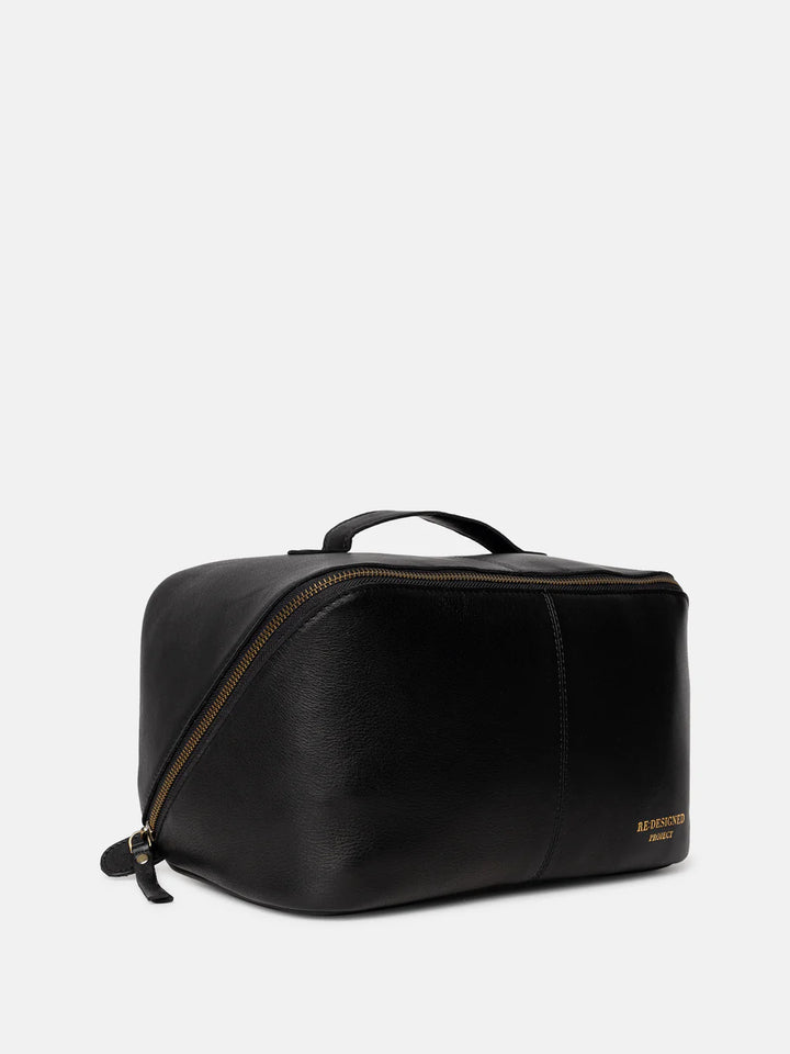 Black leather toiletry bag with gold zipper on a white background