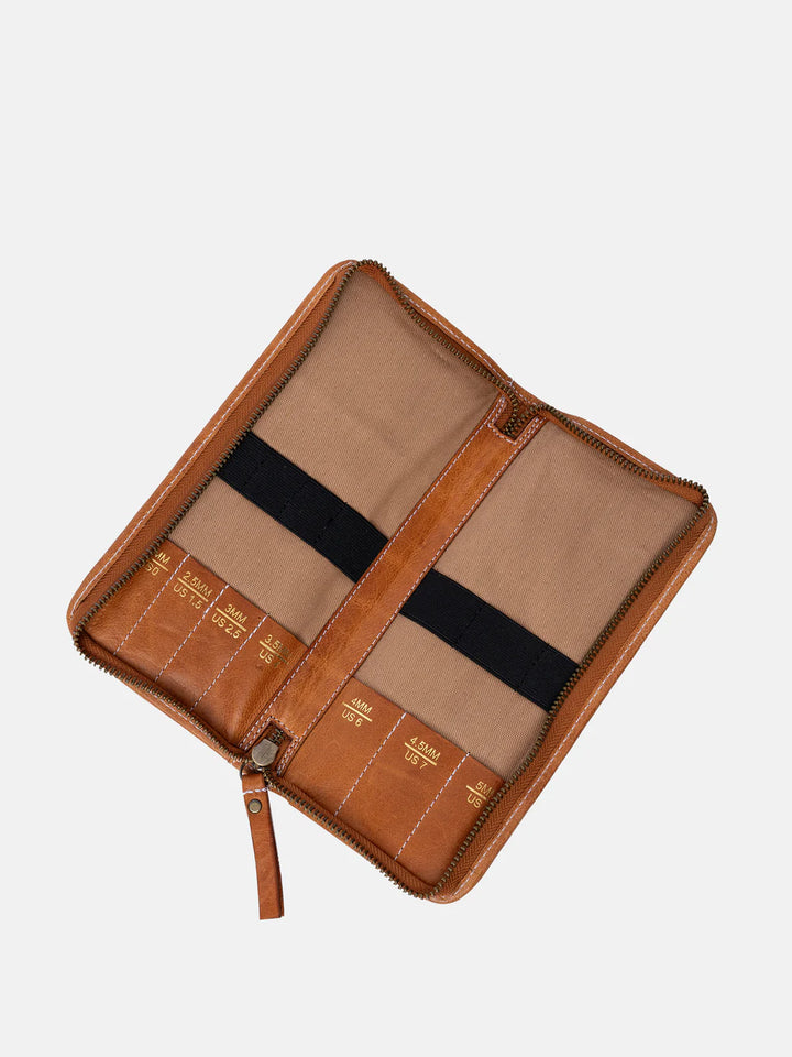Brown leather knitting needle organizer organizer with open compartments on a white background