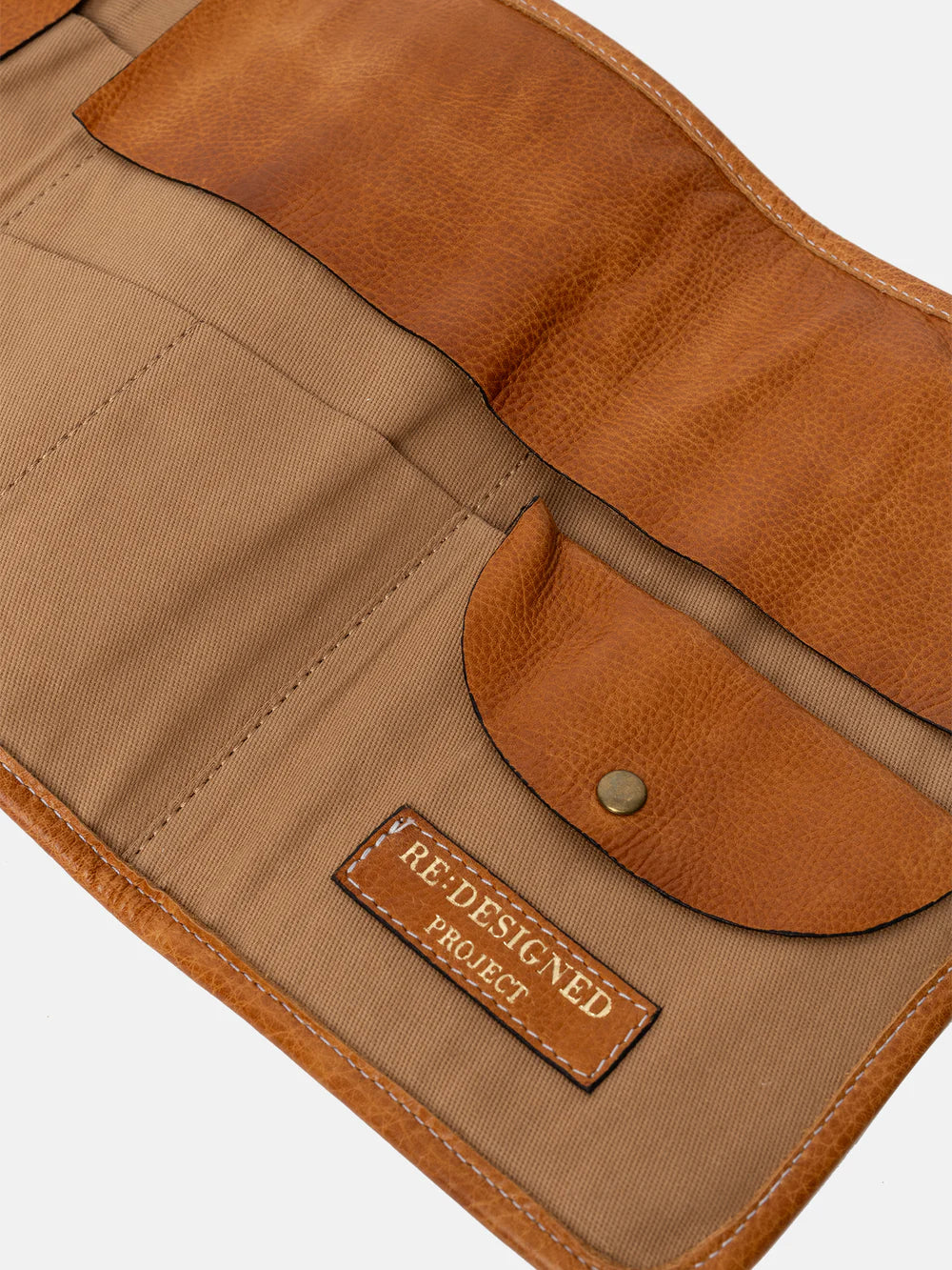 Brown leather and fabric pouch with 'Redesigned Project' label on a white background