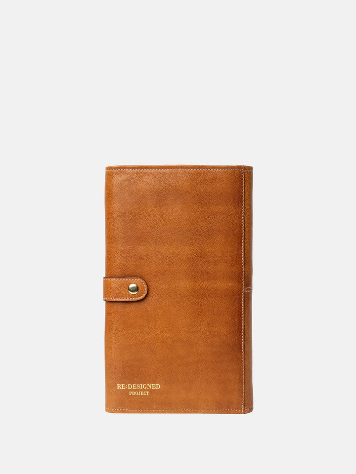 Brown leather needle case with a visible brand name on a white background