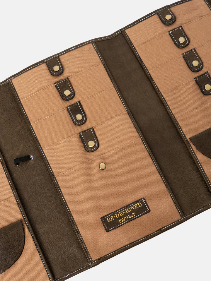 Brown and beige leather needle case with 'Redesigned Project' label on a white background
