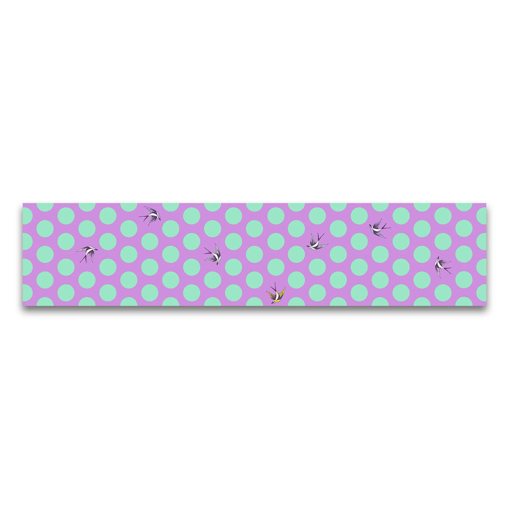 Fabric with bright purple background, large turquoise dots, and birds flying