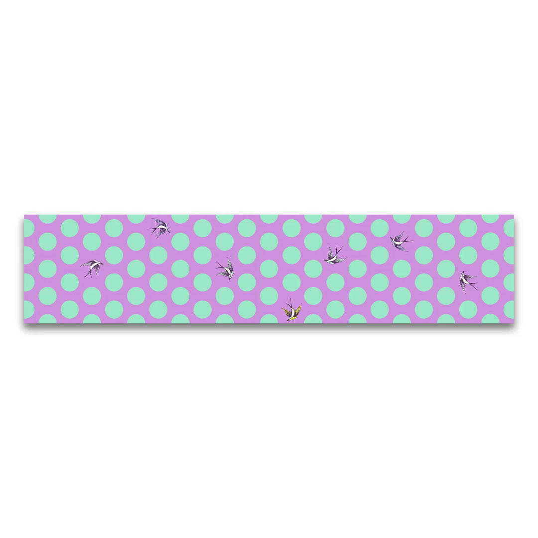 Fabric with bright purple background, large turquoise dots, and birds flying