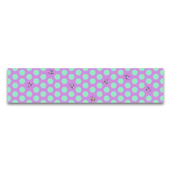 Fabric with bright purple background, large turquoise dots, and birds flying