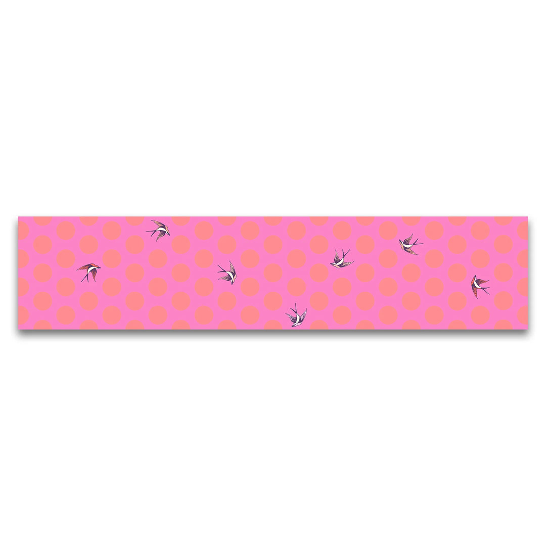 Fabric with a pink background, red large dots, and birds flying 