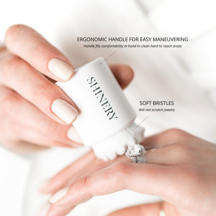 White cleaning brush held by a hand with text highlighting features on a white background