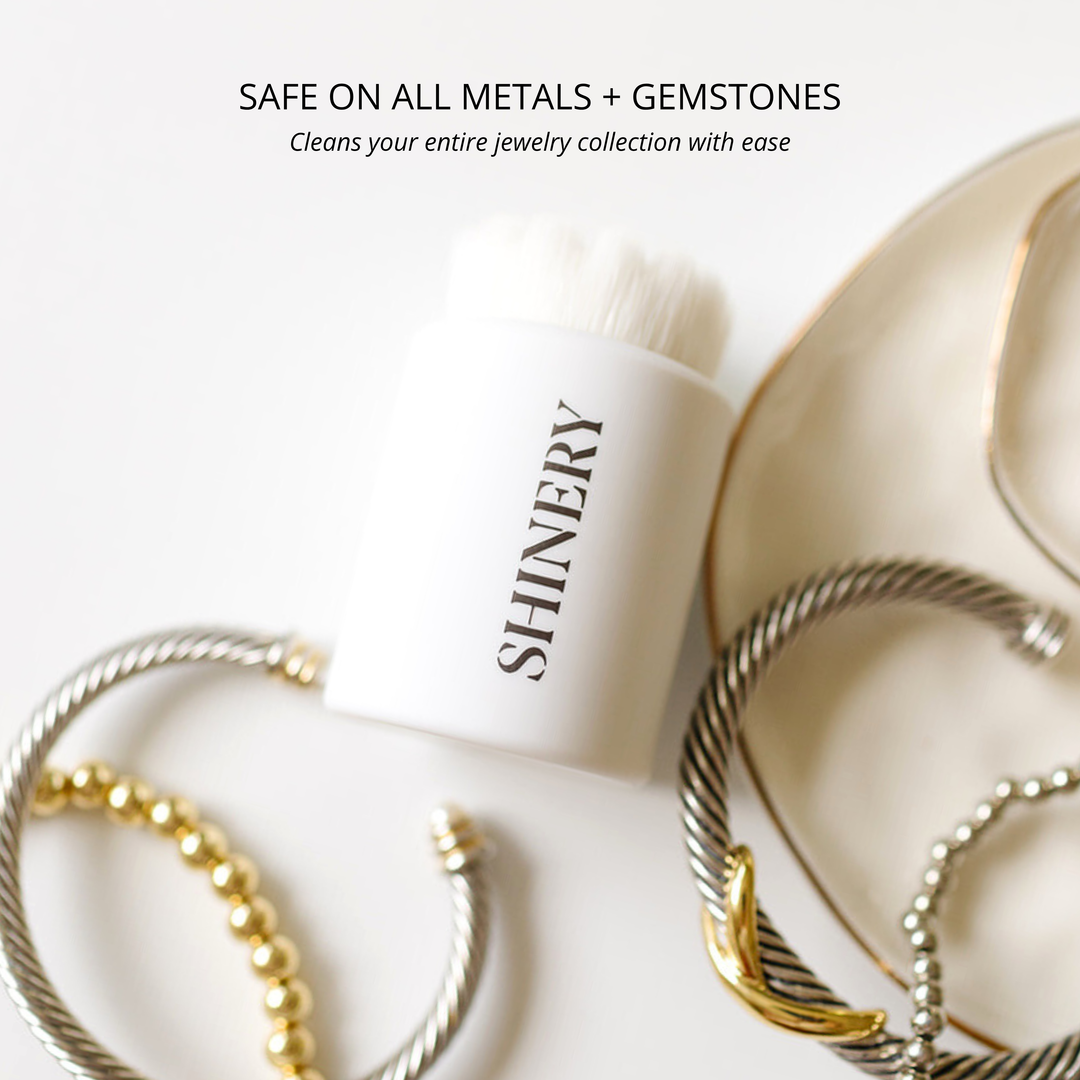 SHINERY jewelry cleaner bottle with gold and silver bracelets on a white background