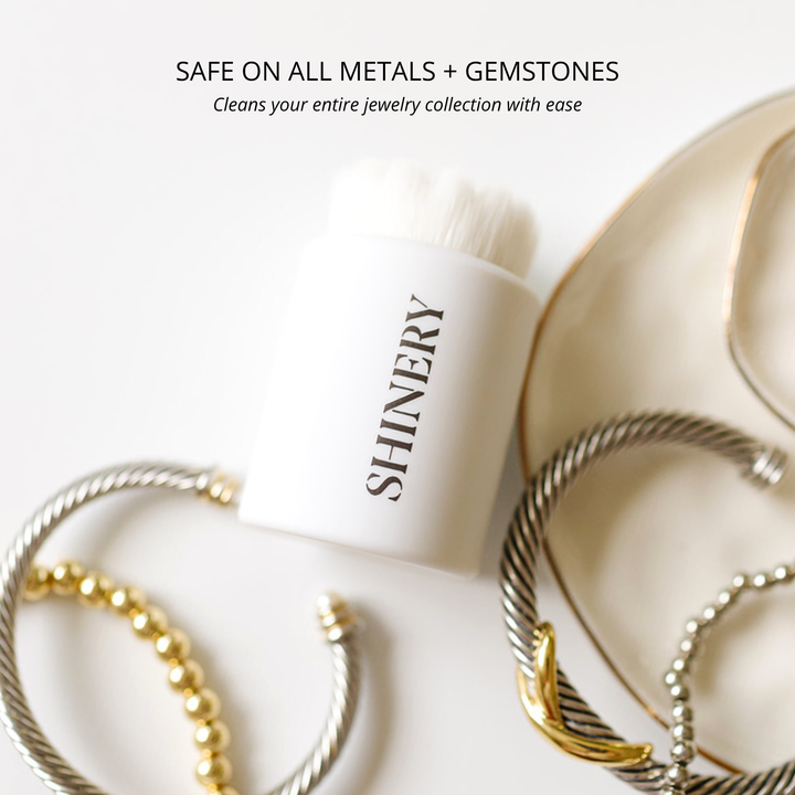 SHINERY jewelry cleaner bottle with gold and silver bracelets on a white background