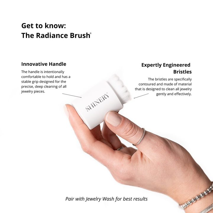 Hand holding a Shinyere Radiance Brush with product details on a white background