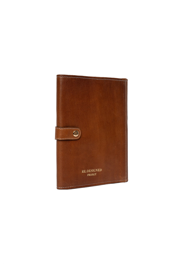A closed walnut brown leather needle case with a gold accent on the snap closure.