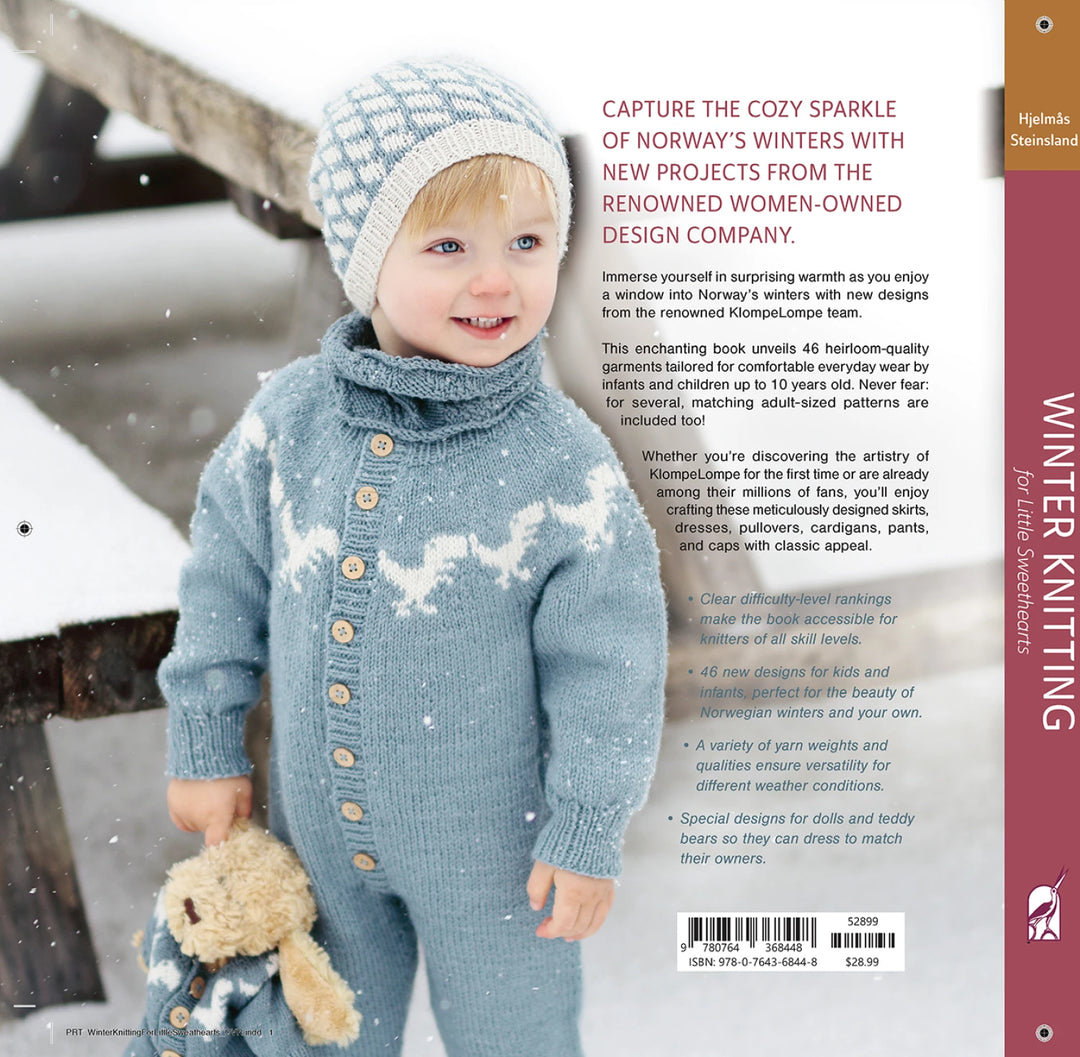 Child wearing a blue knitted outfit with a snowflake pattern, standing in a snowy landscape.