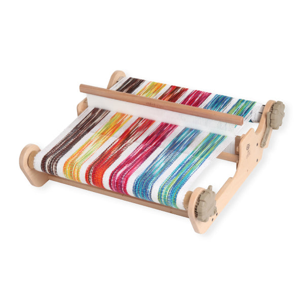 Colorful striped yarn on a wooden loom against a white background