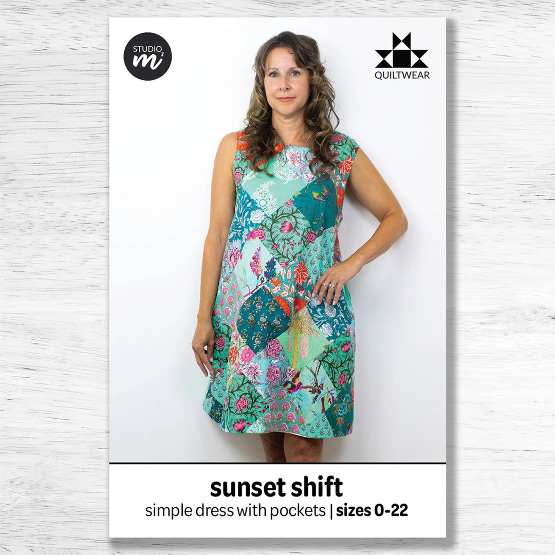 Woman wearing a colorful dress with 'Studio M' branding on a white background