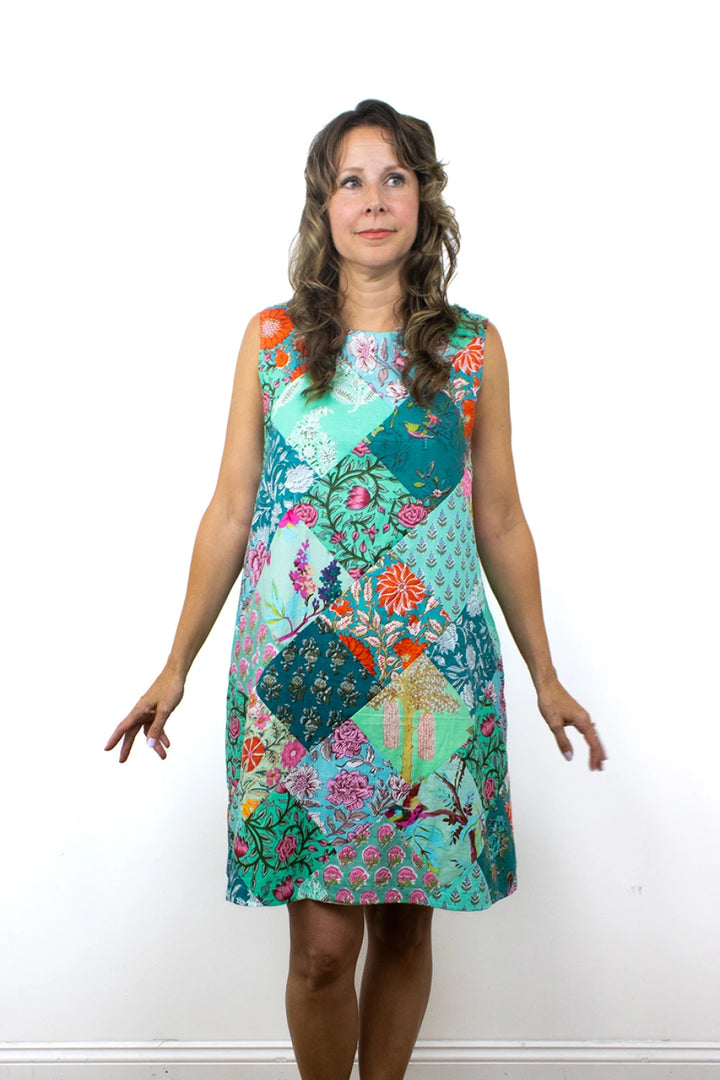 Woman wearing a colorful floral dress against a white background