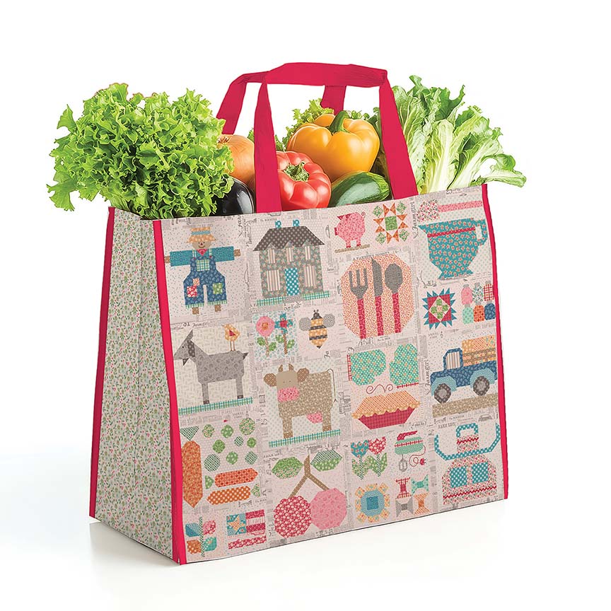 Reusable shopping bag with farm-themed pattern filled with groceries on a white background