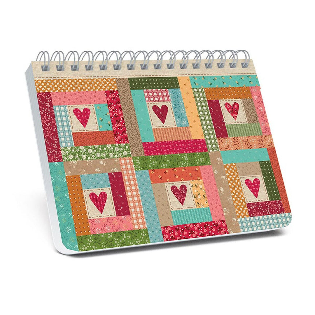 Notebook with patchwork design and heart patterns on a white background
