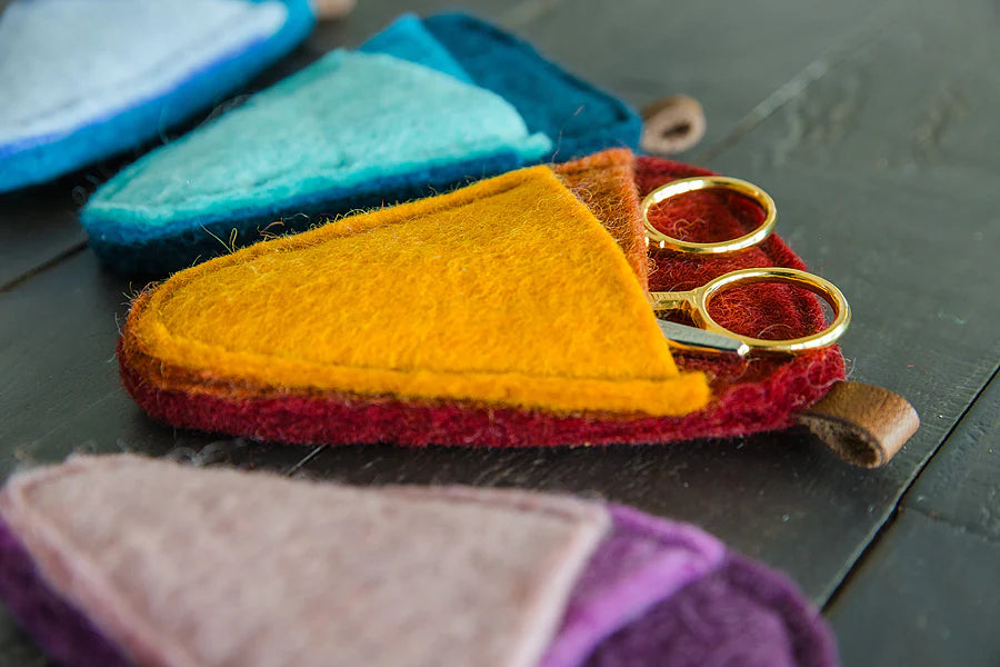A close-up of a red and orange felt scissors sleeve