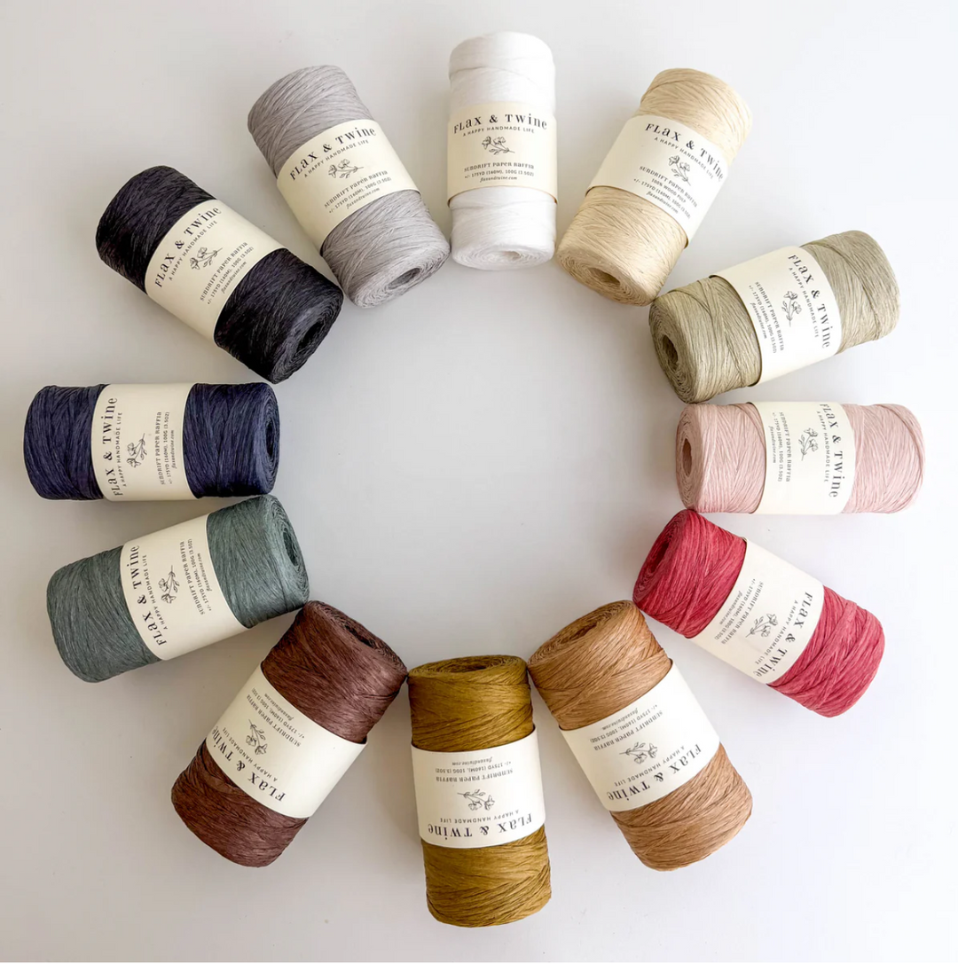 Assorted yarn rolls arranged in a circular pattern on a light background