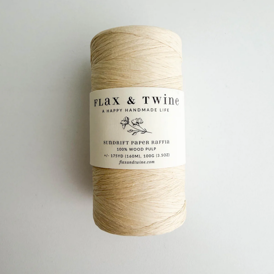 Spool of flax fiber with 'Flax & Twine' label on a light gray background