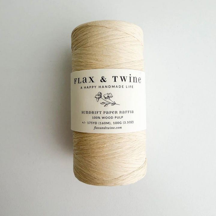 Spool of flax fiber with 'Flax & Twine' label on a light gray background
