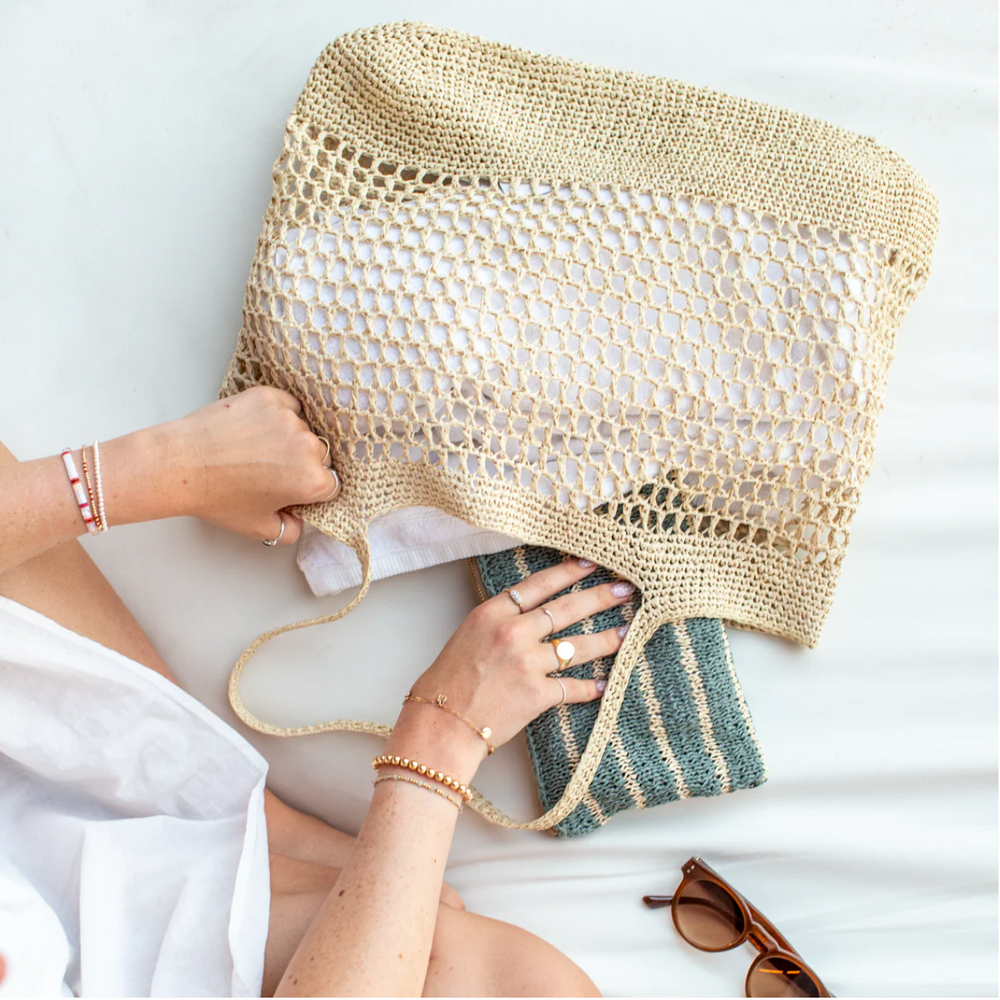 Person holding a woven bag with a white background