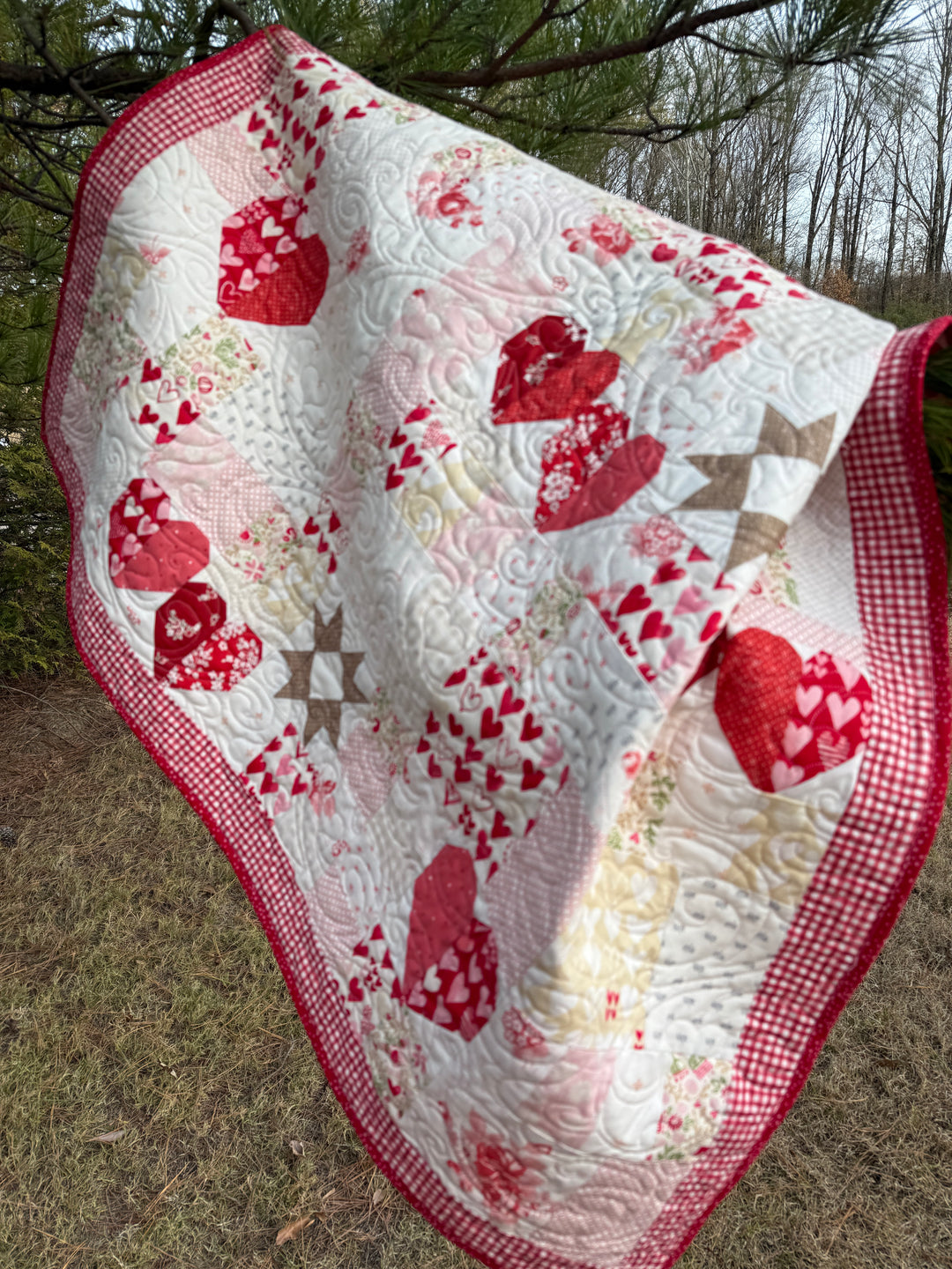 Quilt with red heart patterns on a natural background