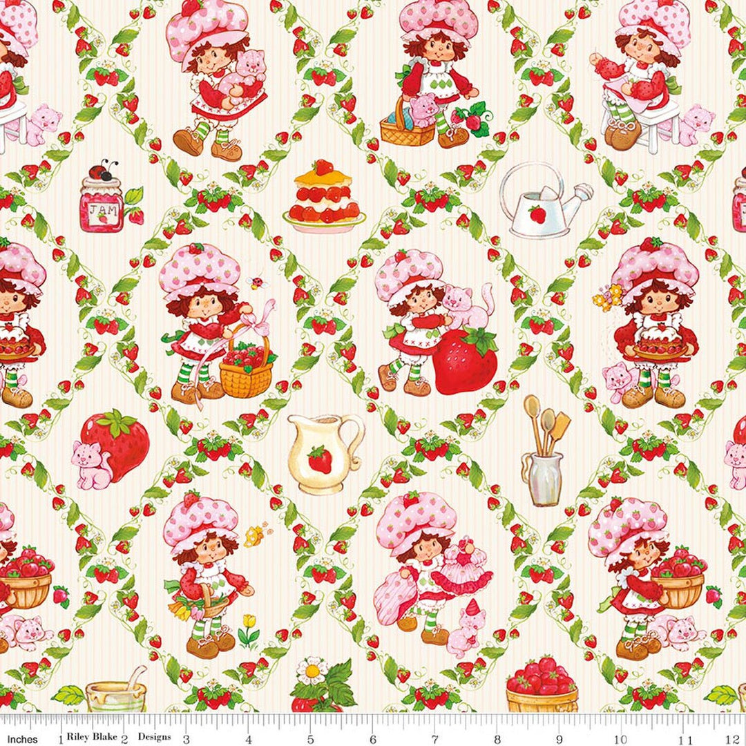 Patterned fabric with Strawberry Shortcake surrounded by strawberries, cakes, and kitchen utensils.