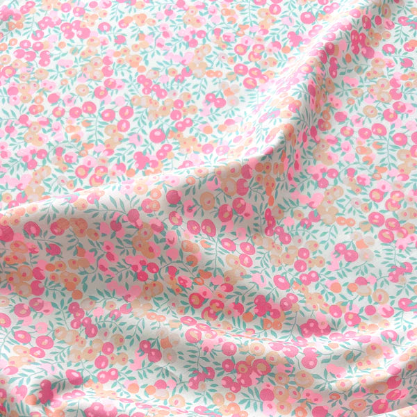 Floral fabric with pink and green flowers on a light blue background