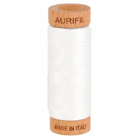 Spool of Aurifil thread with wooden cap on a white background