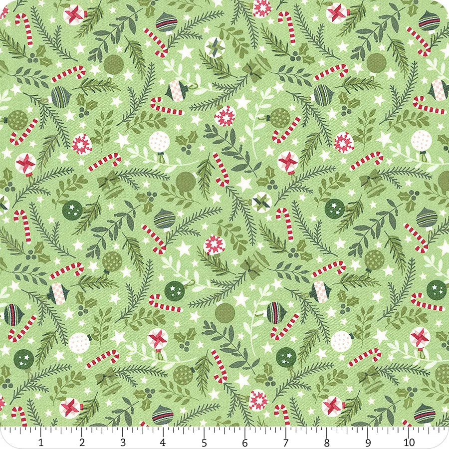 Green fabric with greenery and Christmas ornaments