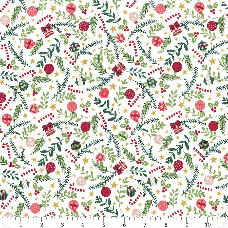 White fabric with greenery and an assortment of Christmas ornaments