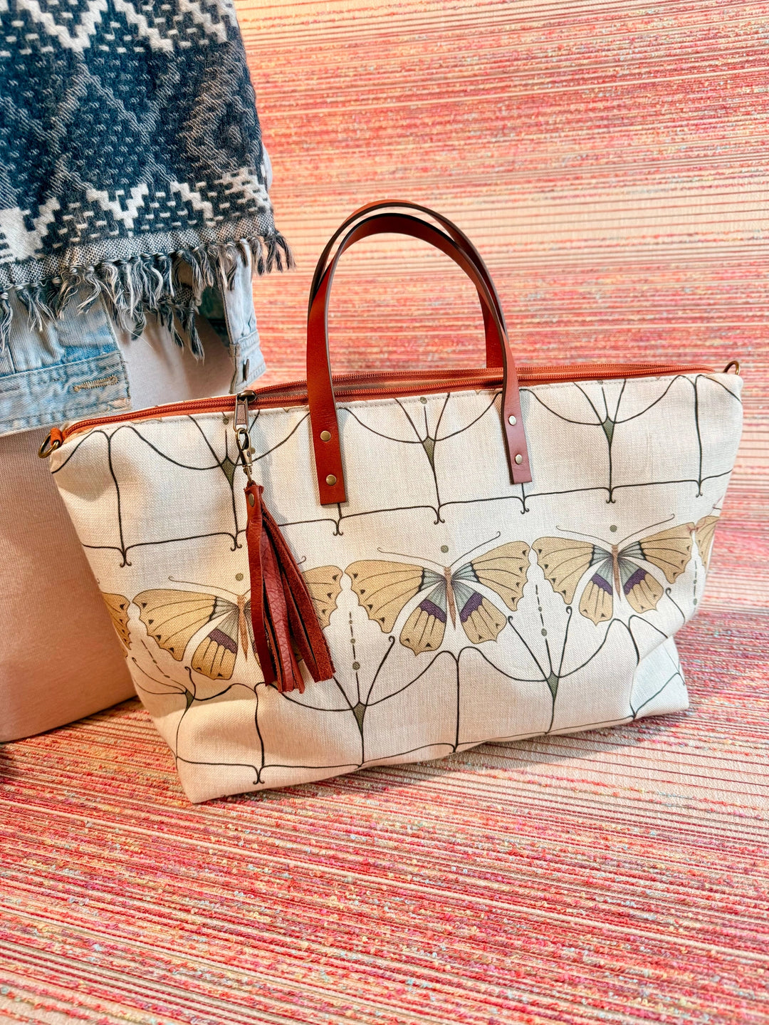 Tote bag with butterfly design on a textured surface