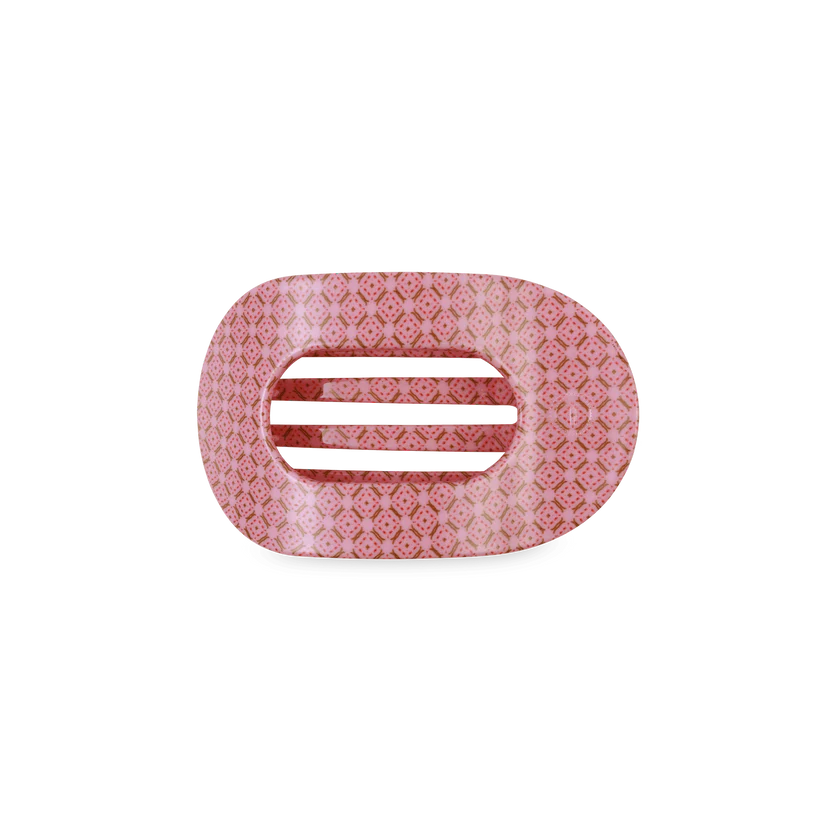 Decorative pink hair clip with a subtle pattern on a white background