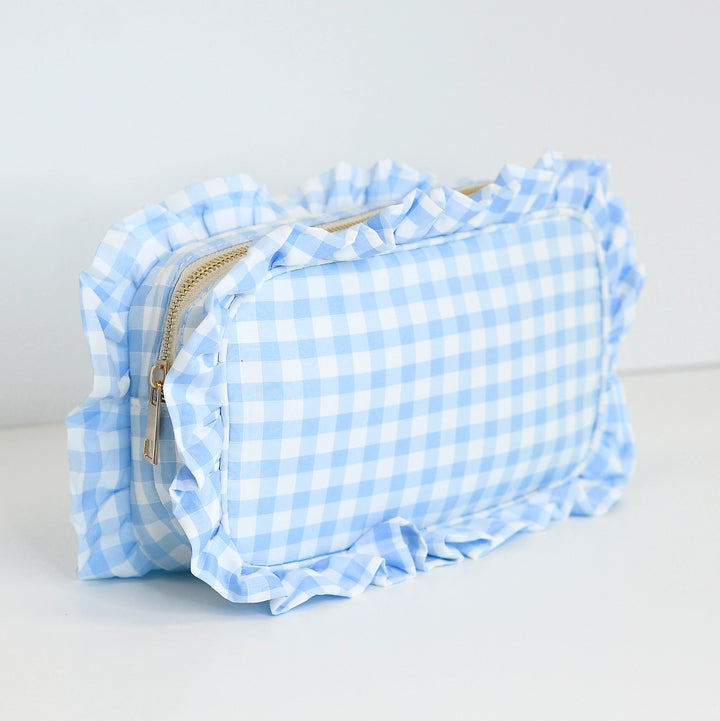 Blue and white checkered pouch with ruffled edges on a light gray background